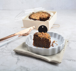 premium freshly baked dark cocoa chocolate brownie gold flower and earl grey peanut round birthday cake with walnut in wood bento box on white marble halal food sweet dessert menu for pastry cafe shop