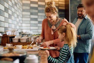 Happy family enjoying in buffet breakfast in hotel.