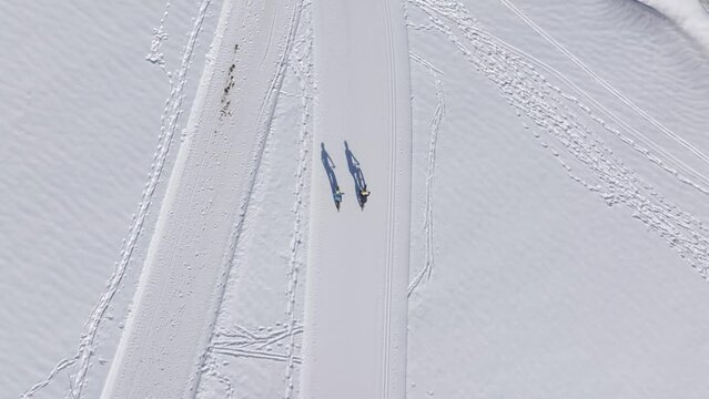 Aerial view of people fatbiking in fresh snow mountain landscape, Ramsau am Dachstein, Austria