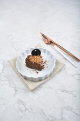 premium freshly baked dark cocoa chocolate brownie gold flower and earl grey peanut round birthday cake with walnut in wood bento box on white marble halal food sweet dessert menu for pastry cafe shop