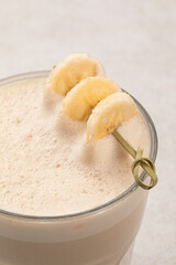 Glass of raf coffee with dried banana on on light background