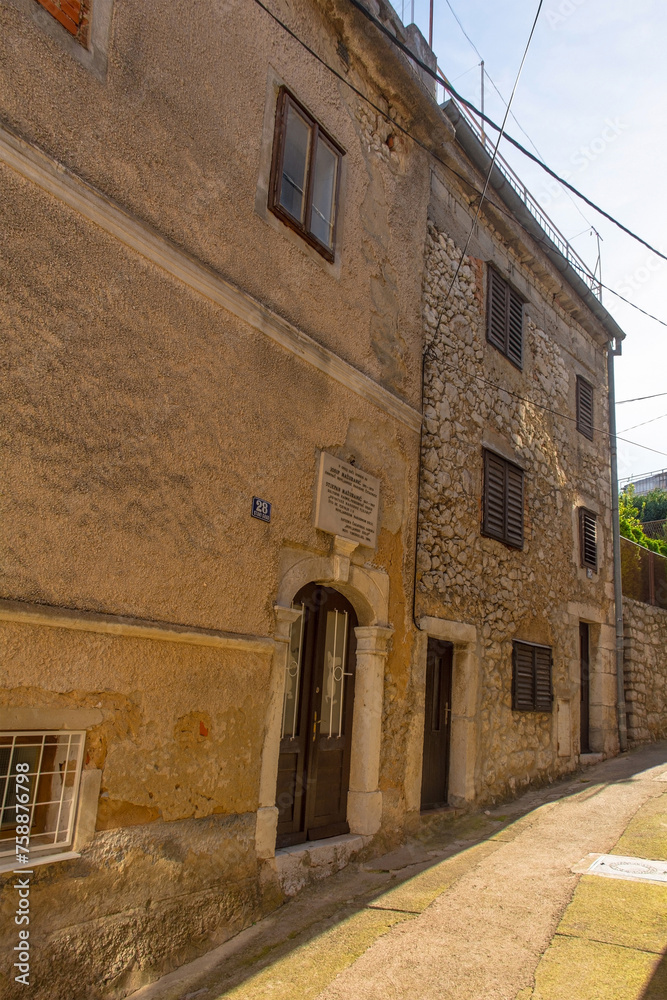 Wall mural A plaque outside the birth house of Canon Josip Mazuranic, founder of the Public Library and Reading Room, and Stjepan Mazuranic, teacher and collector, in Novi Vinodolski on the Croatian coast