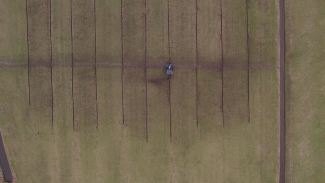 Aerial view of tractor with implement to build ditches in meadow, Netherlands