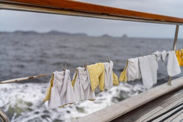 clothes drying on a washing line on a yacht boat traveling over the ocean on holiday. nappies drying on a clothes line on a boat on the sea