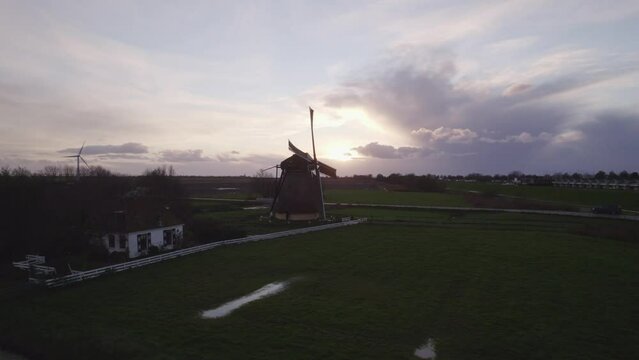 Aerial view of famous spinning Dutch windmill (Nijlannermolen) at sunset, Workum, Netherlands