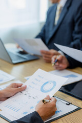 Meeting in the office Teamwork with cost analysis graph, business people on table at conference room