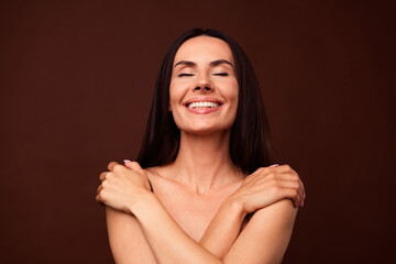 No retouch photo of satisfied lovely woman with brunette hairdo hug shoulders enjoy spa procedure...