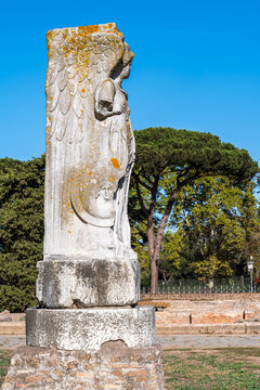 Statue of woman carved in a marble column in the ruins of Ancient Ostia in Italy