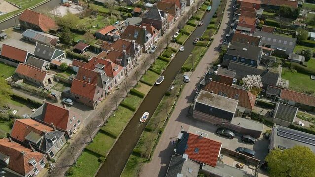 Aerial view of small boat cruising in canal (Ee gracht) during summer, Ijlst, Netherlands