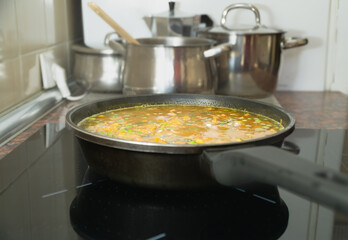 A pot of soup is cooking on a stove