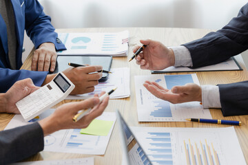 Close up of a team of business people having a meeting to analyze data for a marketing plan.	