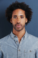 Young man, portrait or confident in studio as creative professional or casual fashion by blue...