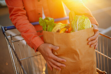 Man holding a bag full of healthy food. The concept of consumerism, proper nutrition, shopping.