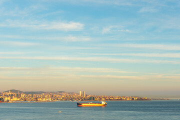 Fototapeta premium Cargo ship moving through Bosphorus during sunset.