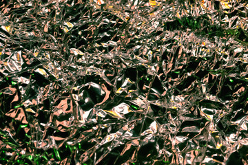 Glare surface. Crumpled aluminum foil. Crinkled background. Colored sparkle