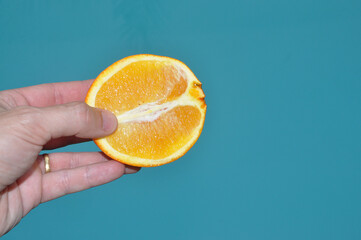 prazer do toque feminino representado por laranja fruta cortada ao meio  