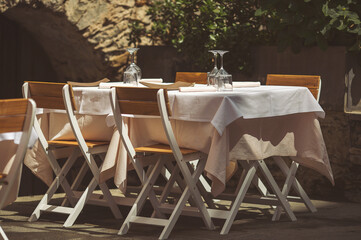 Street view of a coffee terrace with tables and chairs in europe. Old style traditional Italian trattoria restaurant. 