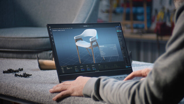Creative man uses professional software for furniture design creation and 3D modeling working on laptop computer. Designer creates digital 3D model of stylish wooden chair, prepares carpentry project.