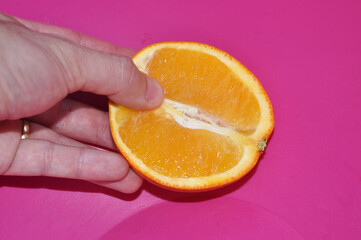 prazer do toque feminino representado por laranja fruta cortada ao meio  