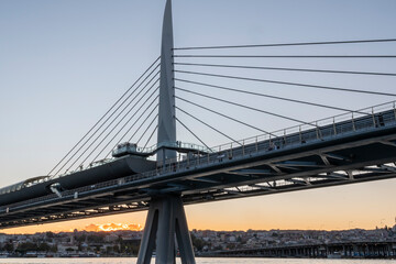 Fototapeta premium metro bridge located on the golden horn of istanbul golden horn with sunset light buildings and balat district in the background