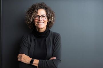 Portrait of a senior businesswoman with arms crossed against grey background