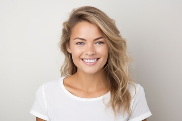 Portrait of a beautiful young blond woman smiling and looking at camera