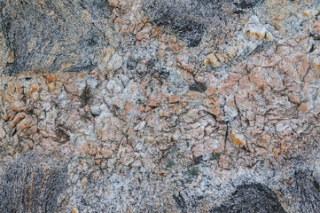 Detailed look at the natural patterns and colors of a granite rock surface.