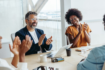 Group of business people applauding in a successful boardroom meeting