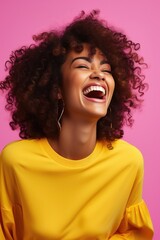 A woman with curly hair laughing in a yellow shirt. Suitable for lifestyle and fashion concepts
