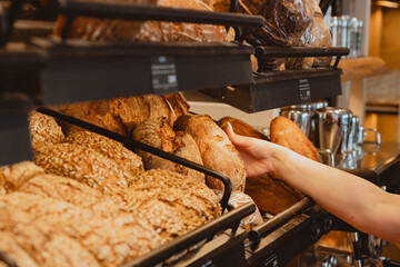 Knusprig braunes Brot nehmen aus einer Auslage in Bäckerei