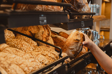 Knusprig braunes Brot nehmen aus einer Auslage in Bäckerei