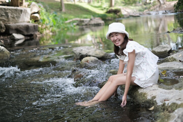 portrait asian woman relax in tropical nature near stream