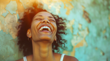 A radiant woman with a bright smile and voluminous curly hair enjoys a moment of genuine laughter amidst lush tropical greenery. This image captures the carefree joy and vitality of youth