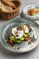 Poached egg with avocado, cherry tomatoes and arugula salad