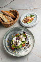 Poached egg with avocado, cherry tomatoes and arugula salad