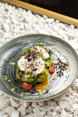 Poached egg with avocado, cherry tomatoes and arugula salad