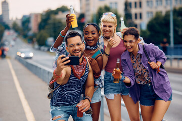 Cheerful group of festival goers taking selfie during summer day.