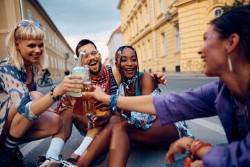 Cheerful friends toasting while attending summer music festival.