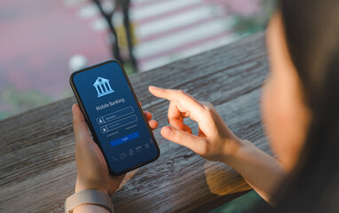 Online payment concept. Over shoulder view of a woman accessing a mobile banking app on her smartphone, highlighting the ease of digital finance management. Internet bank, money transaction, fintech,