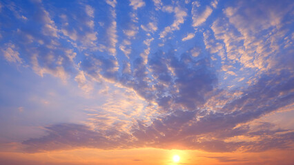 Sunrise sky background with yellow sunlight and dramatic clouds on majestic orange and blue morning sky © Prapat