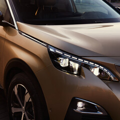 Golden SUV by sunset. Close up of the headlights.