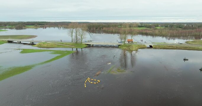Aerial view of high water of river Vecht, rotating along bridge, wire, farm and farmland, Diffelen, Vechtdal, Overijssel, Netherlands