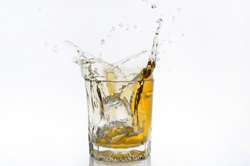 image of the ice cube drop to the glass of whisky and make it splash.