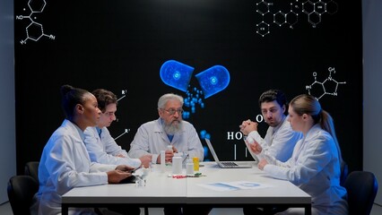 Pharmaceutical research company conference. Multiethnic doctors and scientists having meeting with new drug data visual graphic on big digital screen.
