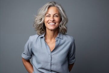 Portrait of a happy senior woman with grey hair over grey background