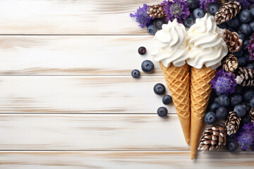 Fototapeta na wymiar Whipped ice cream in cones with blueberries and pine cones on a striped wood surface.