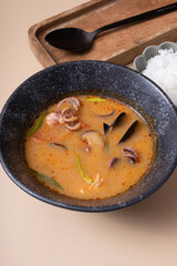 Tom yum soup and rice on a beige background angle view