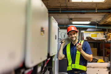 Electrical engineer working in control room. Electrical engineer man checking Power Distribution Cabinet in the control room.