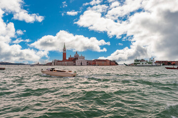 Taxi and other boat traveling on the lagoon and the island of San Giorgio Maggiore in the background in the Venice Lagoon in Veneto, Italy - 758989992