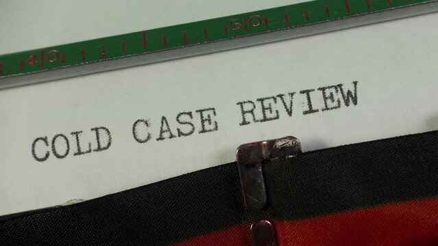 Report of a police investigation into an old crime. Typing Cold Case Review on an old manual typewriter.